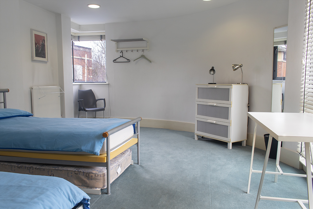Creation Space bedroom one with two double beds, spare mattress and storage