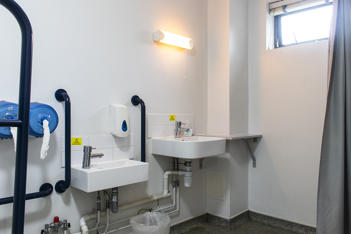 Accessible bathroom of the Creation Space with two variable height sinks and toilet handrails