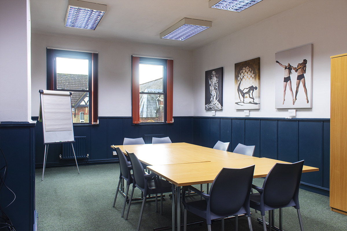 Irving Room in boardroom set-up with desks, chairs, flipchart and photographs of dancers on the wall