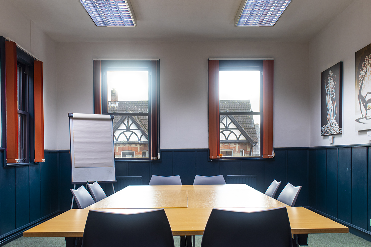 Irving Room in boardroom set-up with desks, chairs and flipchart